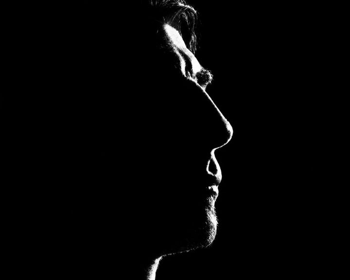 Haig V. in profile, his face traced by a single light against black.