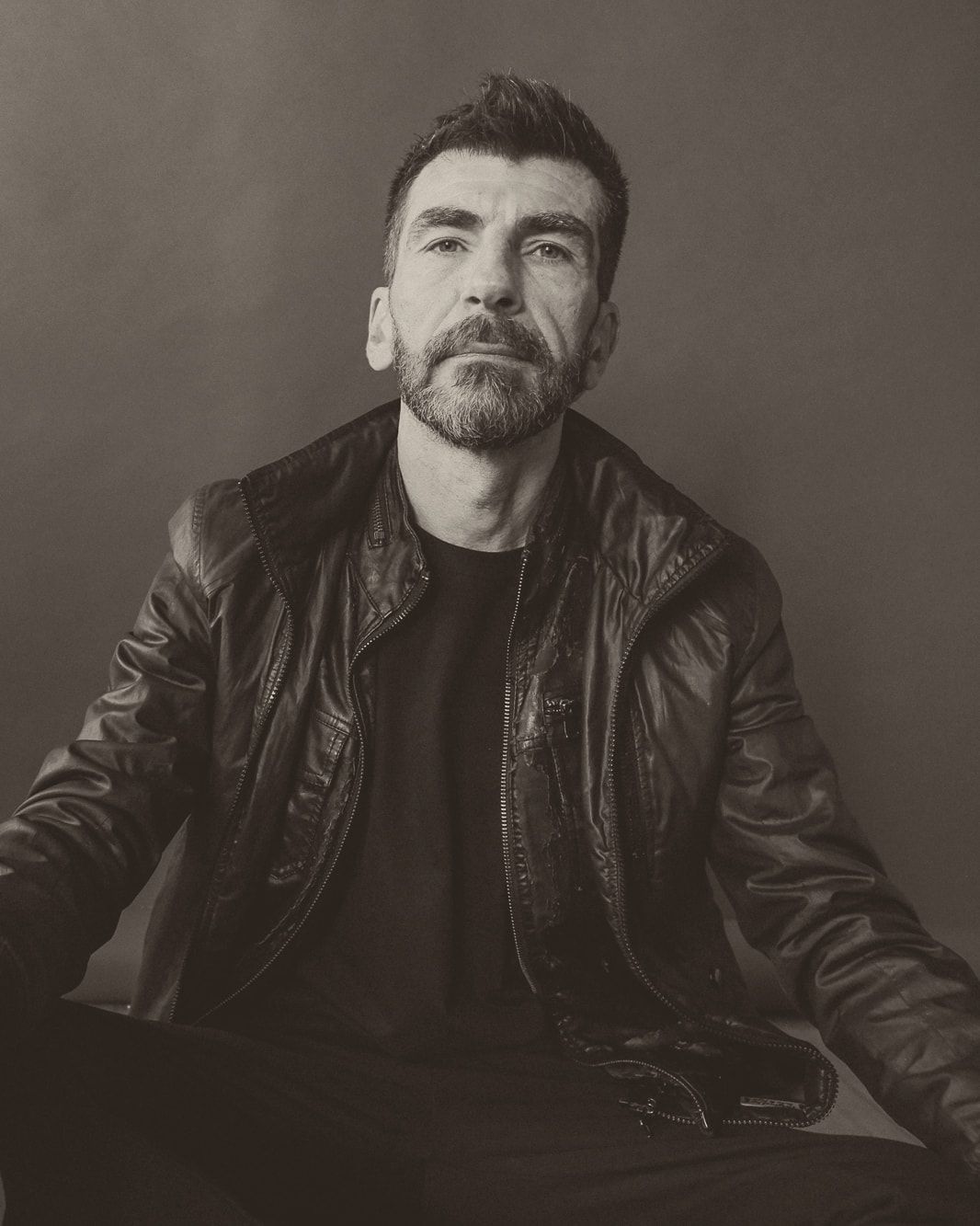 Haig V., seated, in a black leather jacket, looking into the camera.