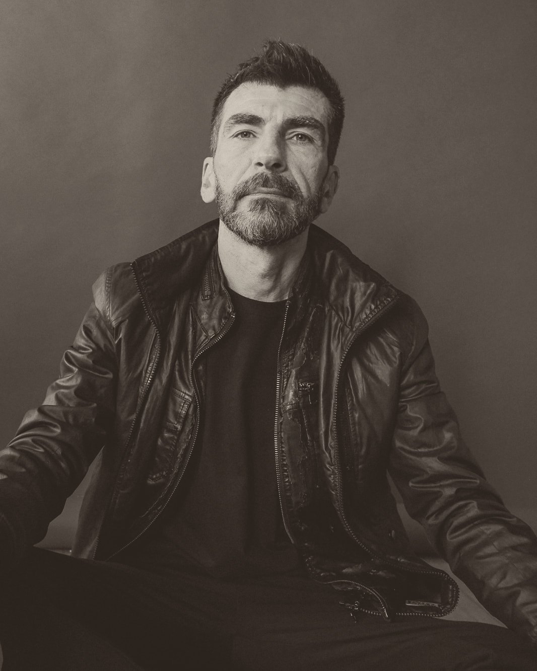 Haig V., seated, in a black leather jacket, looking into the camera.